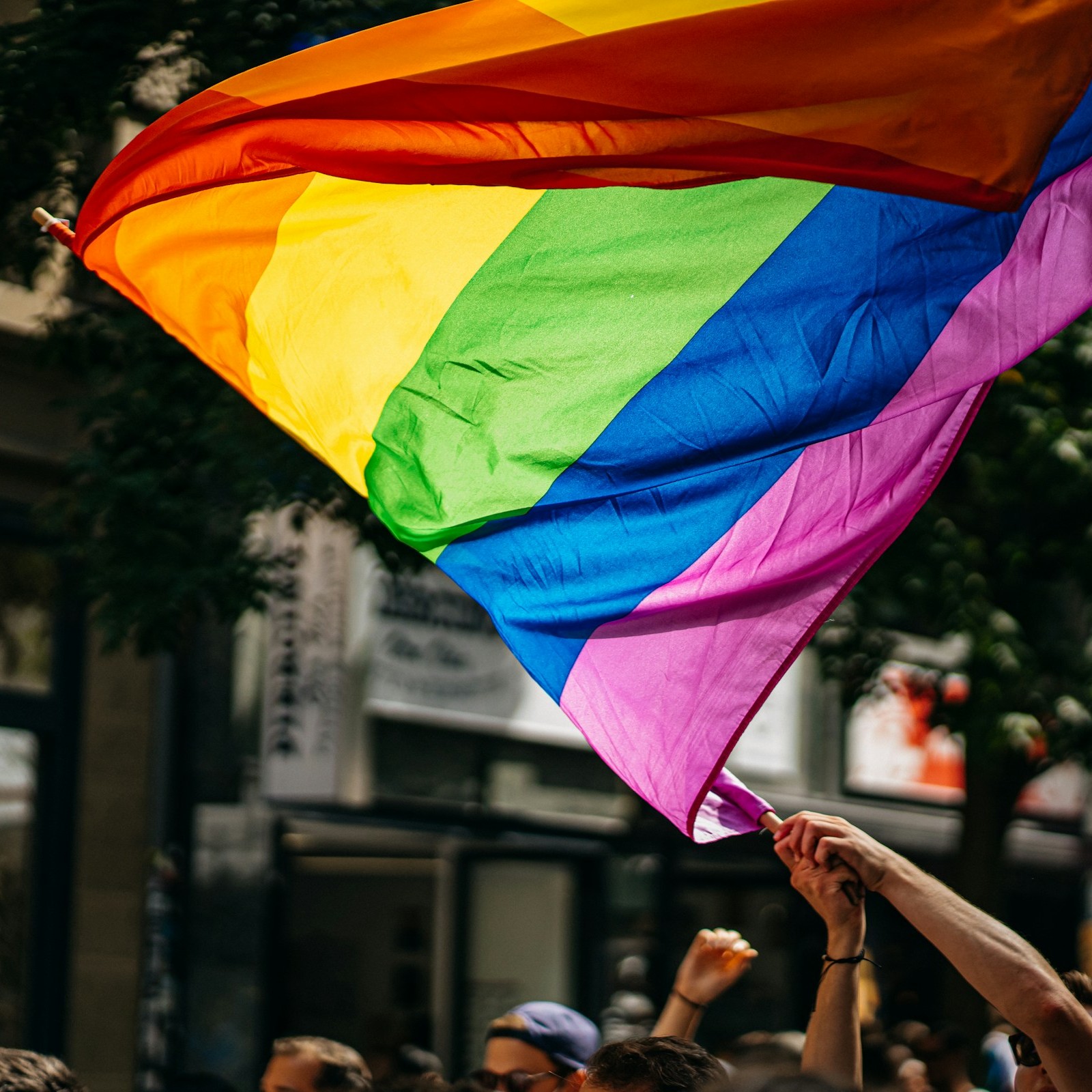 große Regenbogen-Fahne wird in der Luft geschwungen