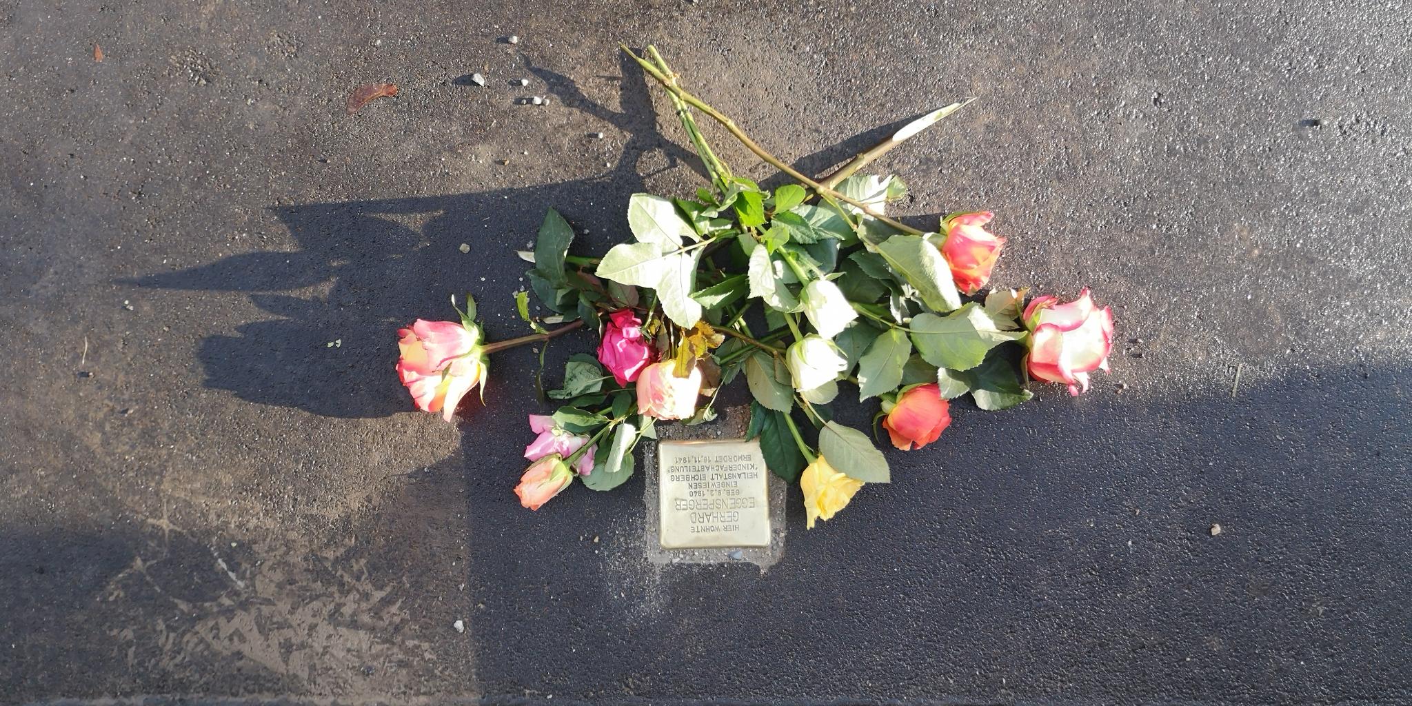Stolperstein, frisch verlegt mit Blumengebinde